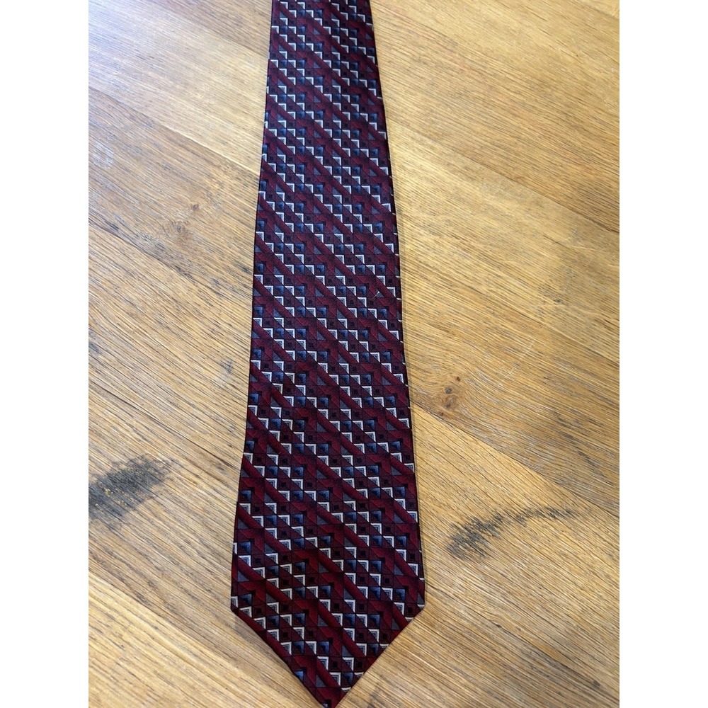 Murano silk necktie featuring a repeating geometric chevron pattern.